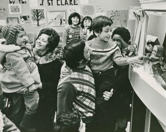Group of children looking at a puppet theatre in the library