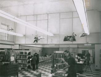 People browse reading material in the children's area of a library.
