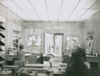 Three women working at desks in the circulation area of a library.