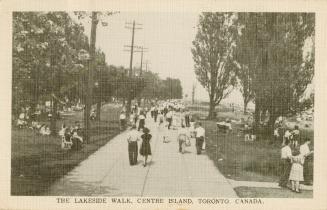A group of people walking on a promenade on Centre Island.