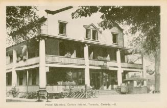 Photo of the front of three storey hotel with large balconies on first and second floors. 