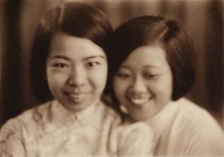 Two young women being next to each other, both smiling