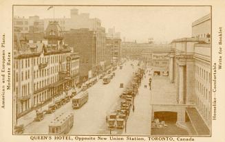 Sepia toned picture of a busy downtown street with street cars and cars. Queen's Hotel is on th ...
