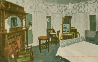 Color picture of a formerly furnished hotel bedroom.