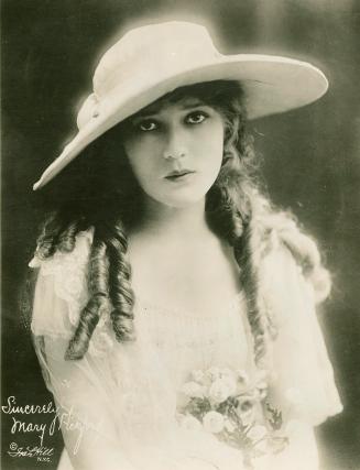 Portrait of Mary Pickford in a white dress and hat.