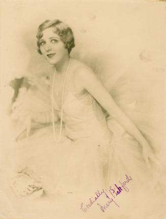 Mary Pickford in short hair wearing a light colored ballet-type of costume.