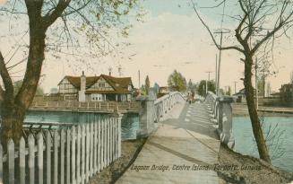 Colorized photograph of a foot bridge crossing a lagoon with a large house to the left of the p ...
