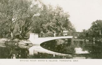 Black and white photograph of people standing on a bridge over a lagoon.