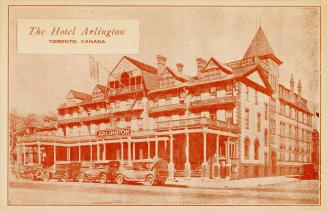 Sepia toned photograph of a four story hotel with four automobiles outside at the front.