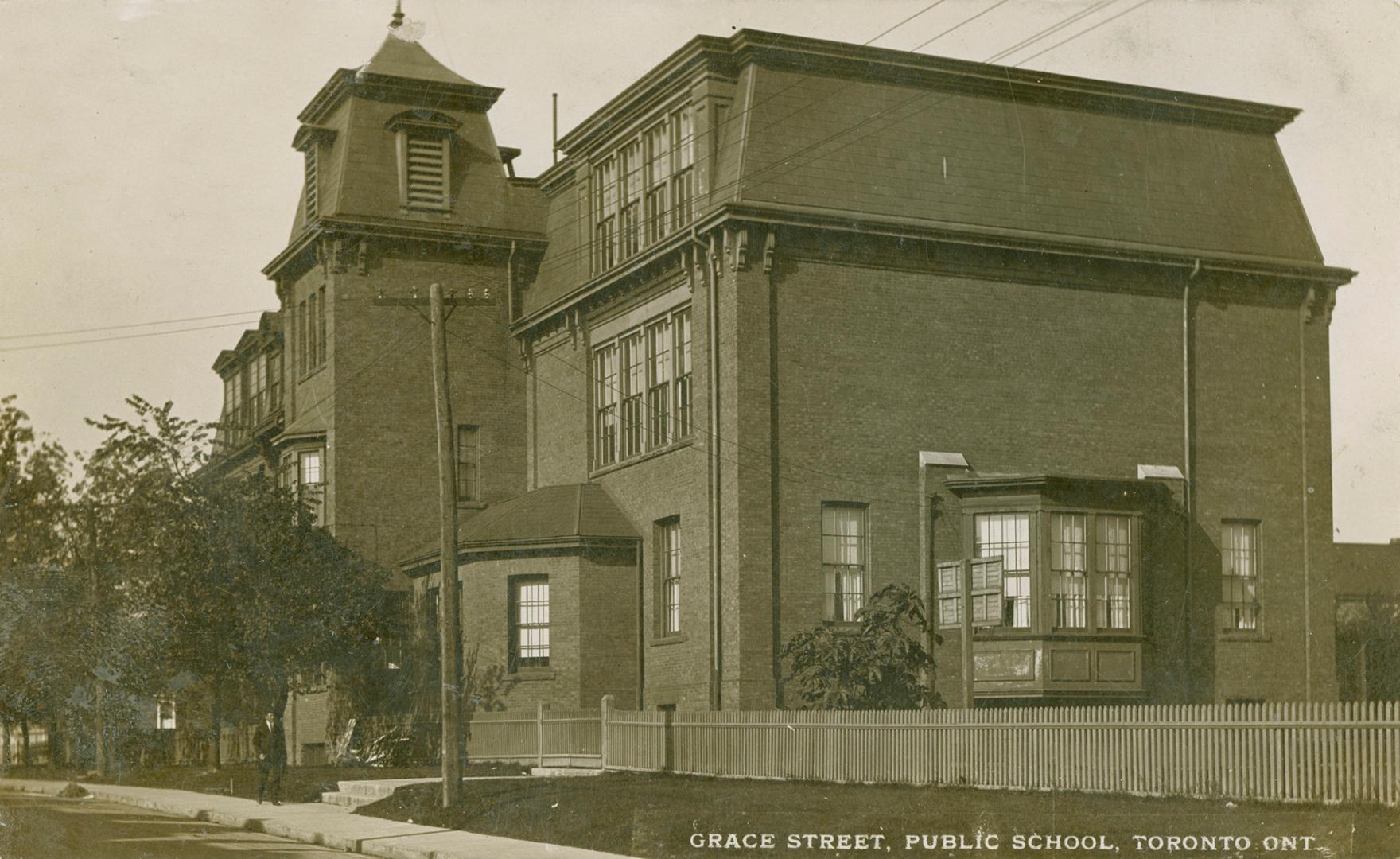 Black and white picture of a three story school with a bell tower.