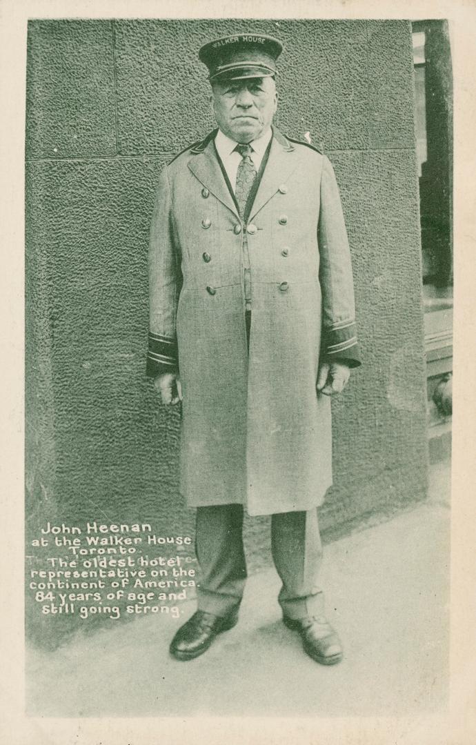 Black and white photo postcard of Doorman John Heenan, standing in front of Walker House Hotel, ...