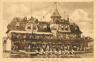 Sepia toned photograph of a large building with people in canoes in the water in front of it.