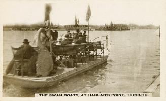 Black and white photo postcard of a Swan Boat ferry with people sitting aboard in rows of bench ...