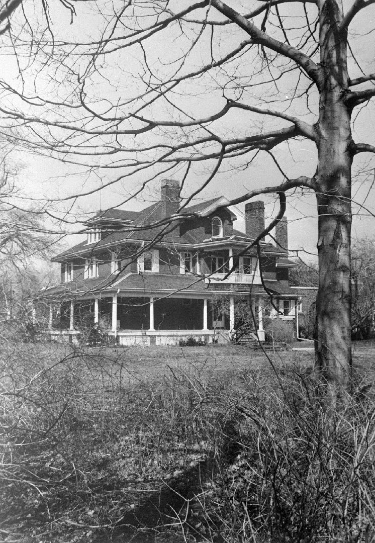 A photograph of a house with a tree in front of it.