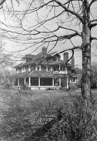 A photograph of a house with a tree in front of it.