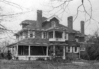 A photograph of a house with a porch and a second floor balcony.