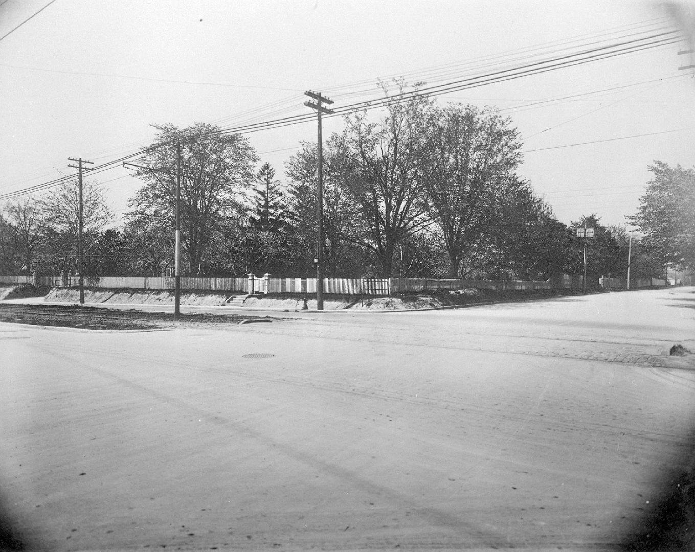 A photograph of a road and a fence in the background.
