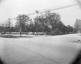 A photograph of a road and a fence in the background.