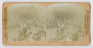 Pictures show men in dress uniforms riding along a city street with crowds looking on.