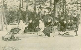 A large group of men and women dressed in everyday clothes on a bobsleigh called Foxy Quiller.  ...