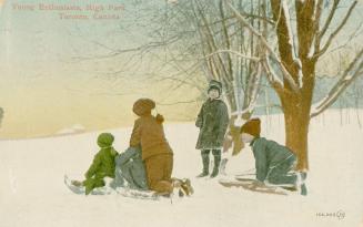 Four children tobogganing in the snow.