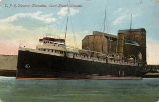 Color picture of a large back steamship at dockside.