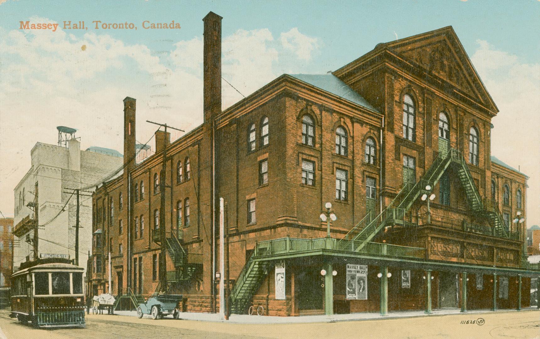 Color picture of a large building with prominent fire escapes. Streetcar appears to the left.