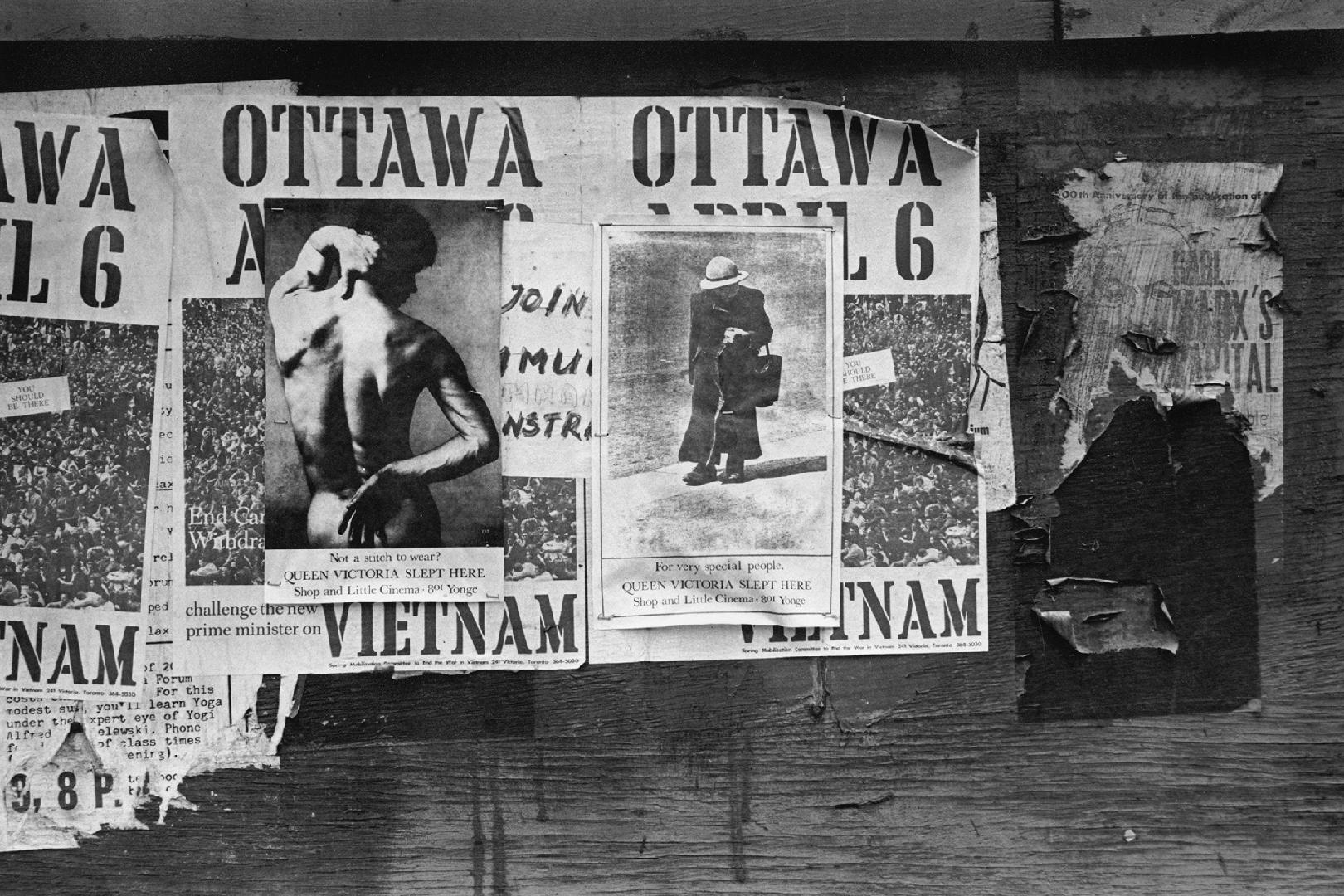 A photograph of torn posters plastered on a wall.