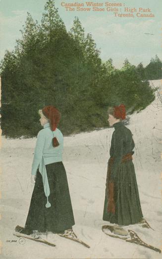 Two women in long skirts snowshoeing in a snow covered park.