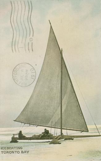 Picture shows two people sitting in an ice boat on a frozen body of water.