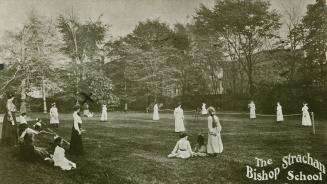 Students and teachers on a lawn playing tennis or badminton.