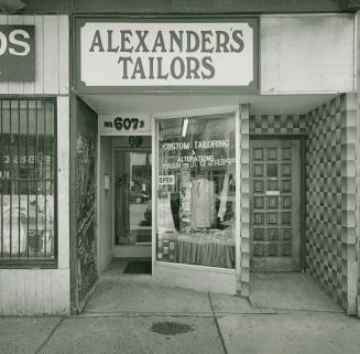 A photograph of the windowed facade of a store named Alexander's Tailors.