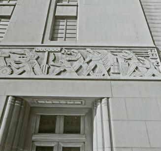 A photograph of a frieze above a doorway, depicting workers in various industries and professio…