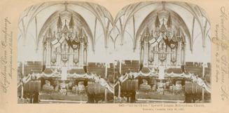 Pictures show show the interior of a large NeoGothic style church, decorated with festoons.