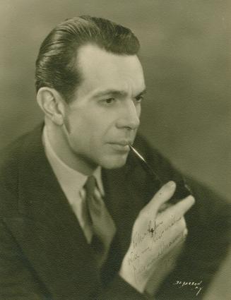 Black and white, head and shoulders shot of a man with a pipe. 