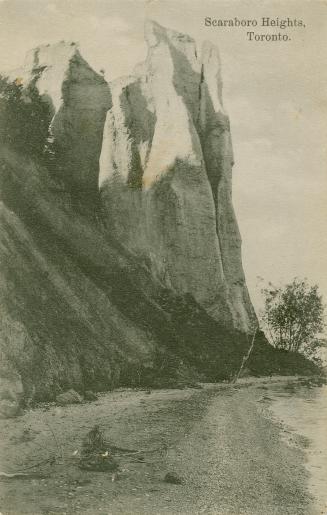 Black and white photograph of two cliffs taken from a beach.