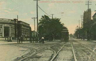 Street scene with street car and tracks; public library to the left.