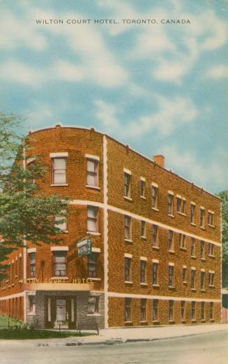 Color picture of a four story hotel building showing a corner front entrance.