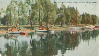 Colorized photograph of sailboats lined up on a shore of a lagoon with trees.
