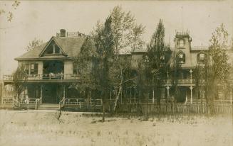Black and white picture of a three story hotel of stick style architecture; massive verandahs.