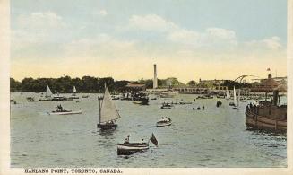 Sailboats and rowboats on a lake.