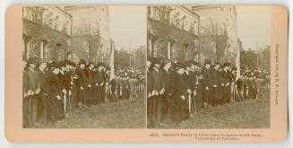 Pictures show a large university building with a huge line up of formally dressed men standing  ...