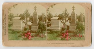 Pictures show two boys looking at a monument in a graveyard.