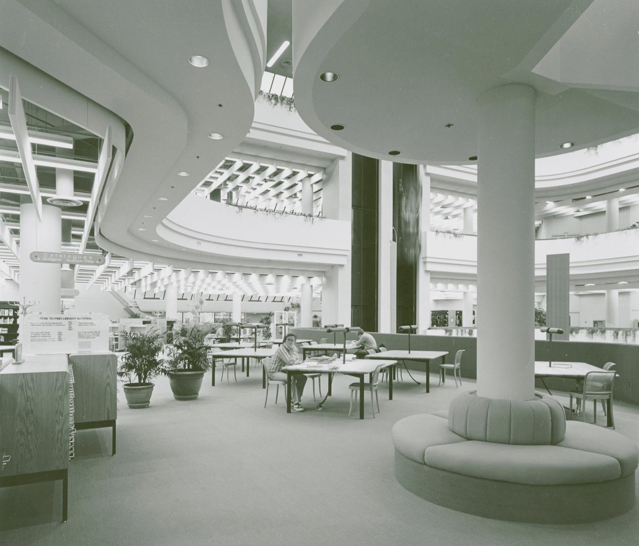 Picture of tables and large study area in the Metropolitan Toronto Library with two people seat ...