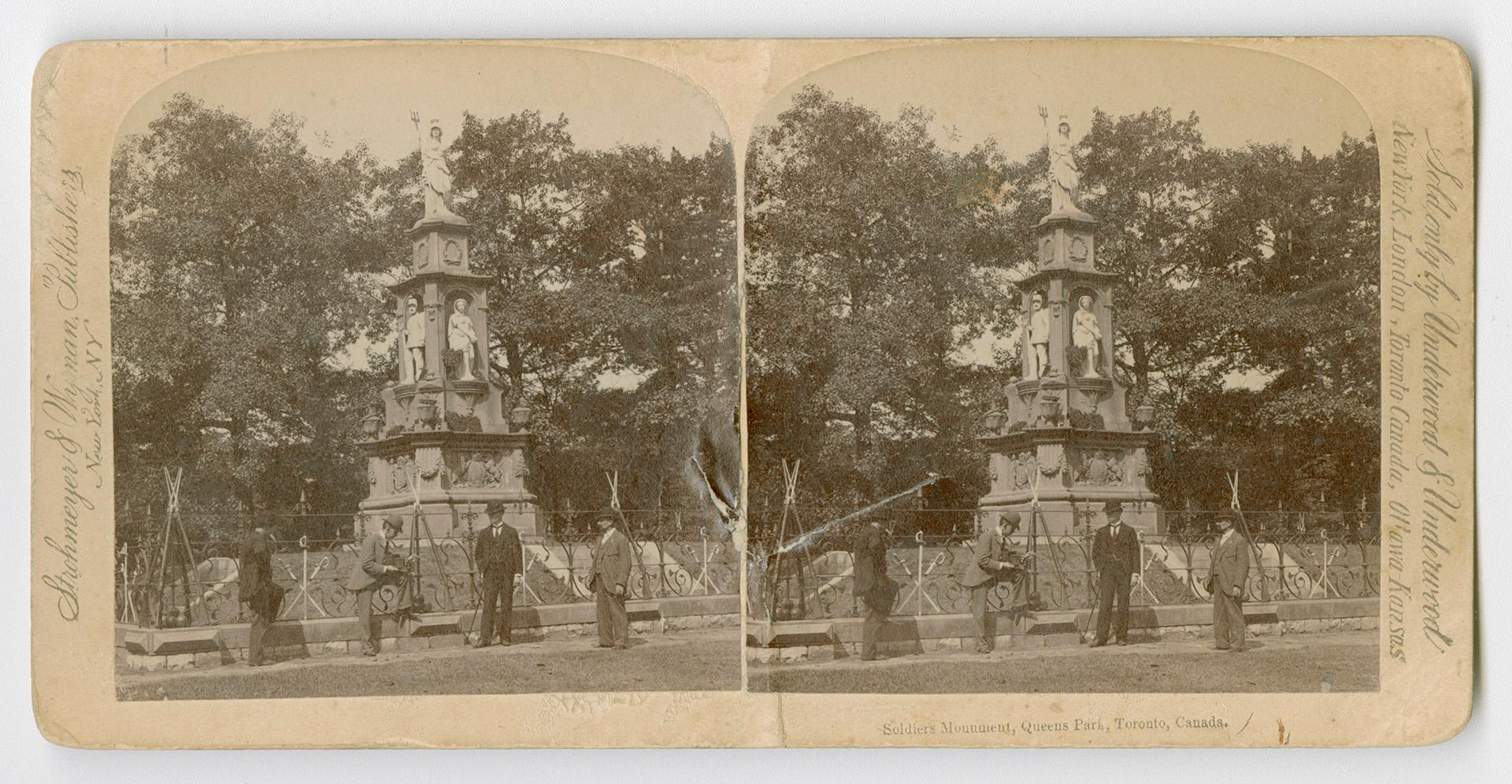Pictures show four men standing in from of a large memorial with steps leading up to it.