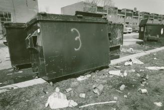 Photograph of garbage disposal bins in Flemingdon Park, with townhouses in background (black an ...
