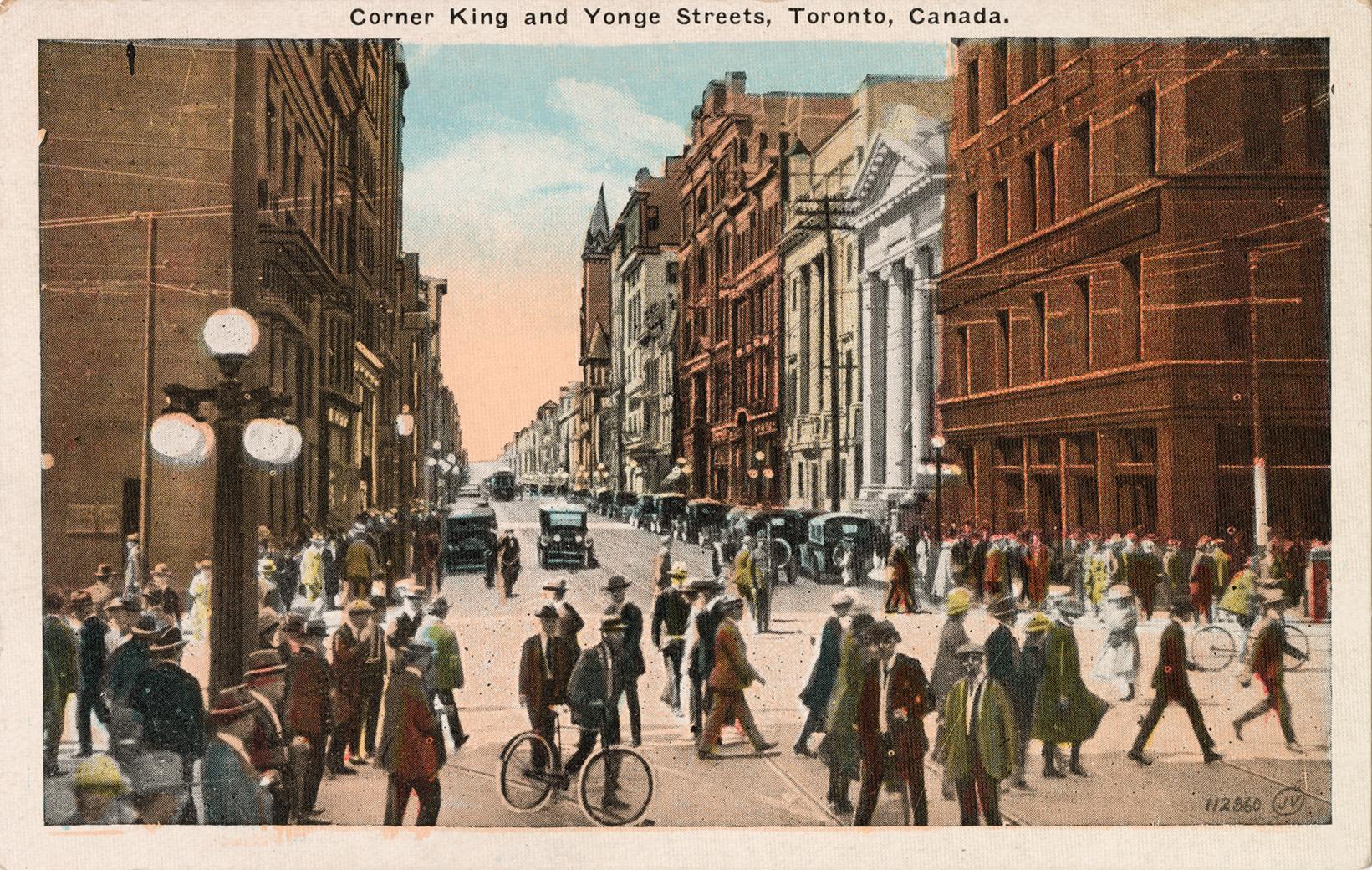 Colorized photograph of a busy downtown intersection with people crossing the street.
