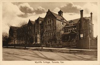 Sepia toned photograph of a four story school building immediately next to a large Victorian ho ...