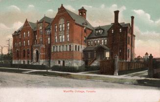 Colorized photograph of a four story school building immediately beside a large Victorian house ...