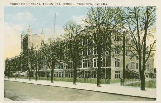 Colorized picture of a four story Collegiate Gothic building with a fence and a row of trees in ...